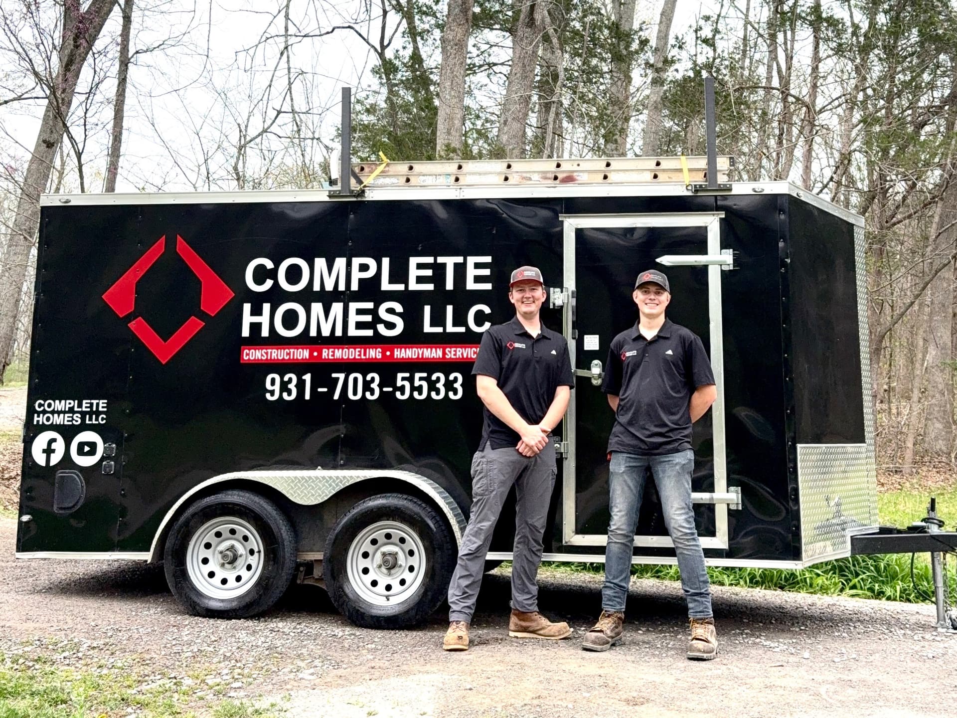 Complete Homes LLC team standing in front of their branded work trailer